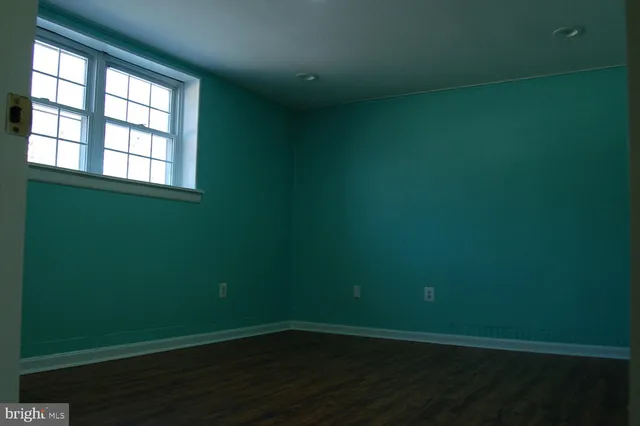 a view of a room with wooden floor and a window