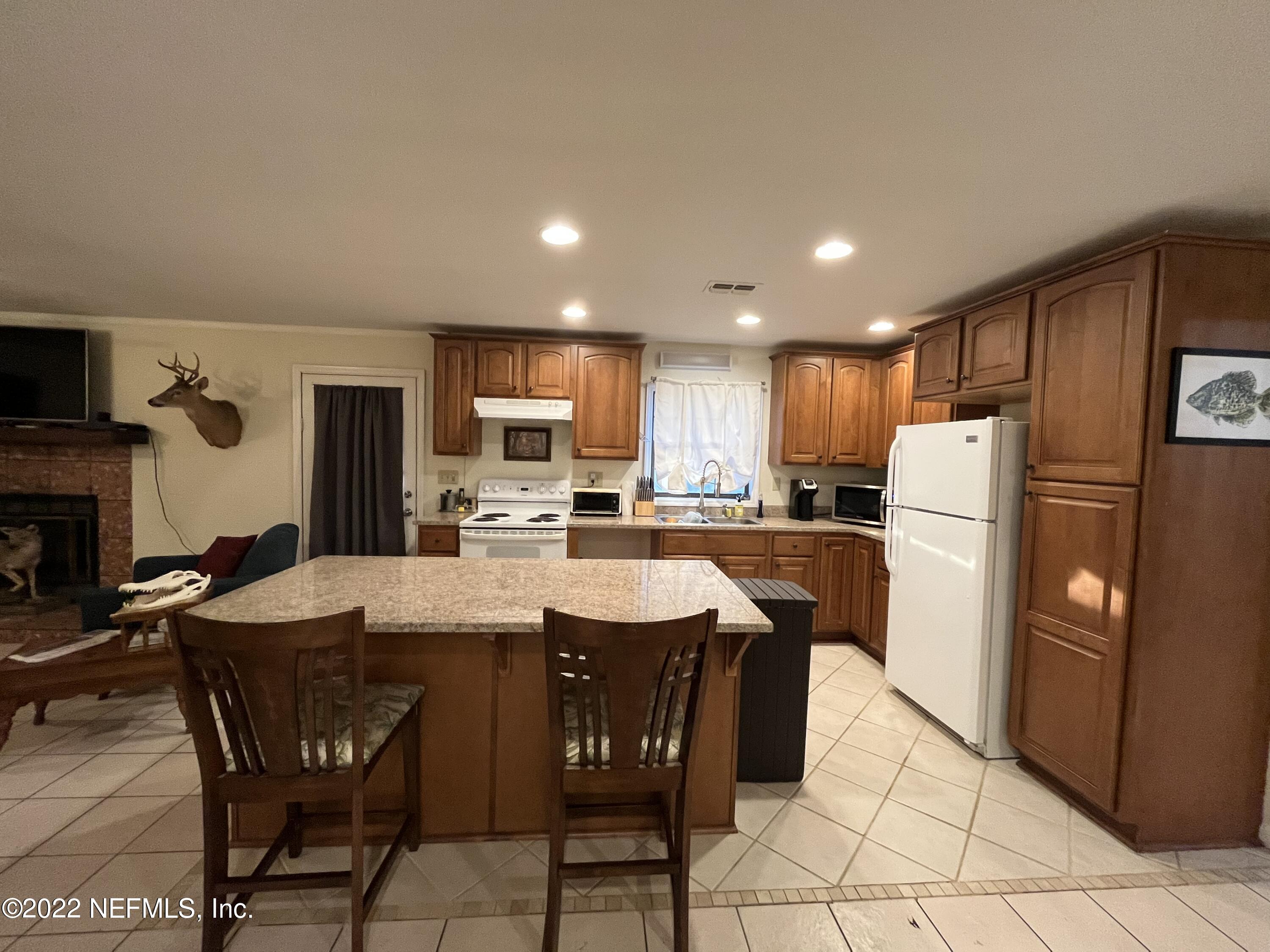 75049 Edwards Road Yulee, FL 32097 - Photo 5 of 23 a kitchen with stainless steel appliances granite countertop a refrigerator a sink a stove a dining table and chairs
