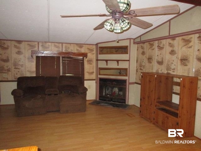 20705 Greek Cemetery Road Robertsdale, AL 36567 - Photo 9 of 25 Living area with light wood-style flooring, lofted ceiling, ceiling fan, and a fireplace