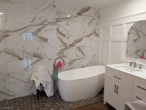 a white bath tub sitting next to a white sink and vanity