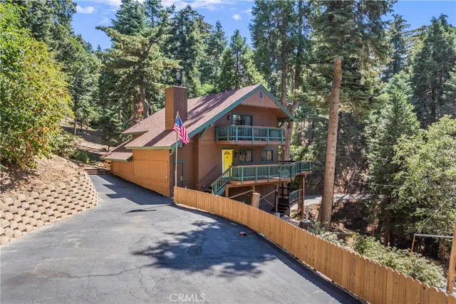 a front view of a house with large trees