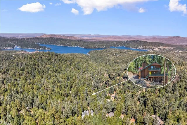 an aerial view of a house with a mountain