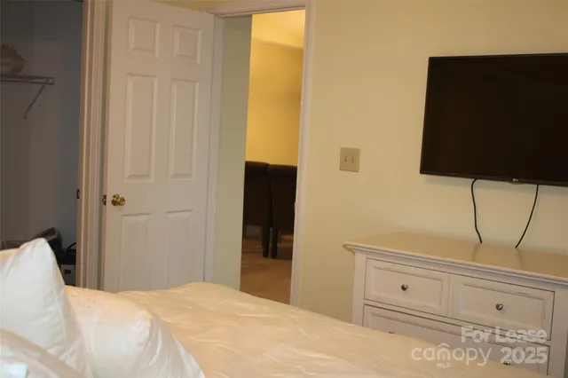a bedroom with a bed and flat screen tv