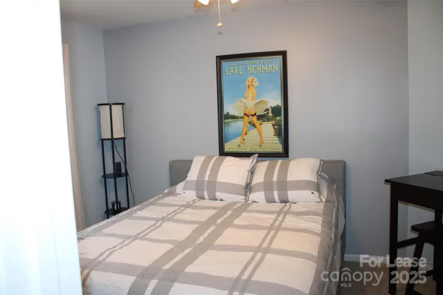 a bedroom with a bed and painting on the wall