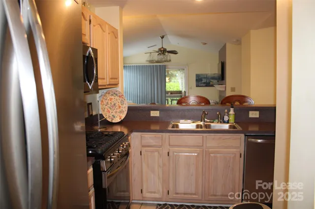 a kitchen with a sink a stove cabinets and a window