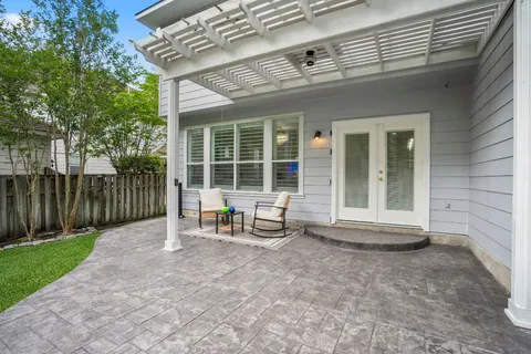a view of a yard in front of a house with plants and large tree