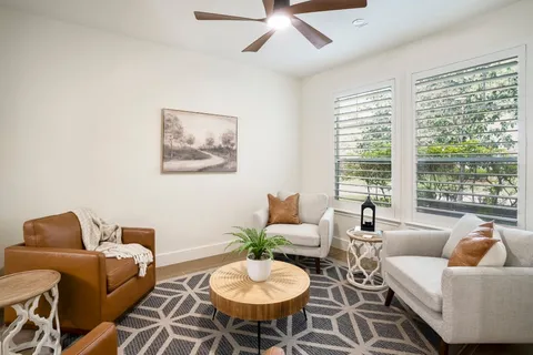 a living room with furniture a large window and a chandelier