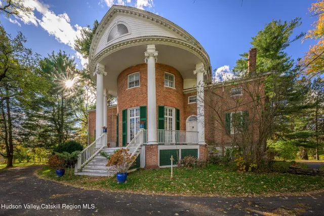 a view of a big house with a big yard and large trees