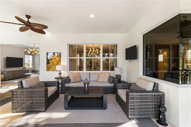 a living room with furniture a flat screen tv and a window