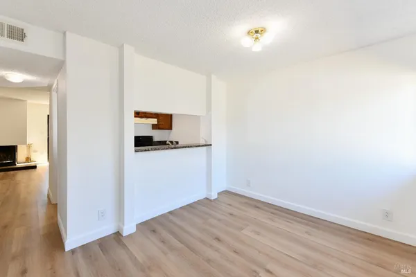 a view of a kitchen with wooden floor and a refrigerator