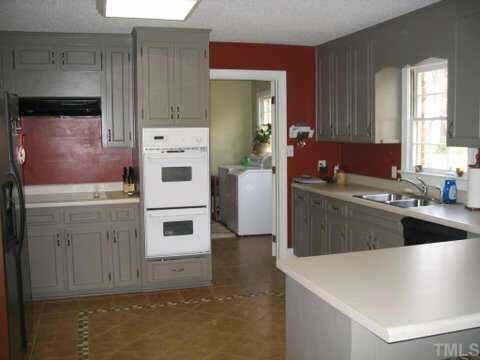 7405 Baystone Court Raleigh, NC 27615 - Photo 5 of 10 a kitchen with stainless steel appliances a white stove top oven and sink