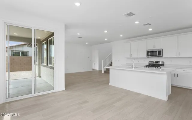 a view of kitchen with stainless steel appliances refrigerator oven and cabinets