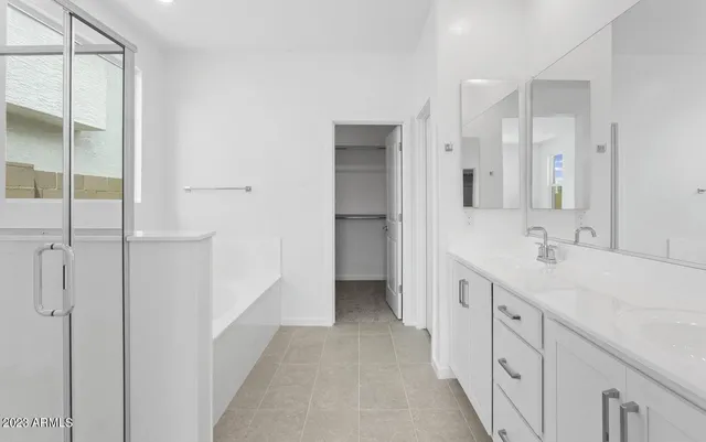 a spacious bathroom with a double vanity sink a mirror and a shower