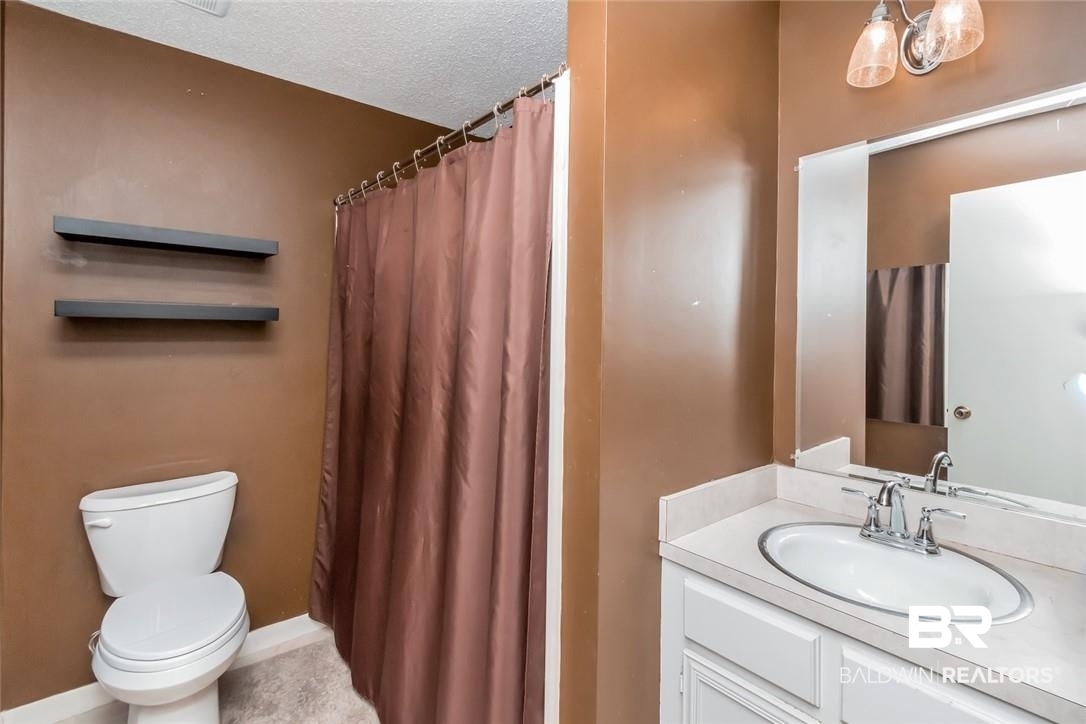 305 Fern Hill Court Mobile, AL 36608 - Photo 38 of 53 Bathroom with a shower with curtain, vanity, toilet, and a textured ceiling