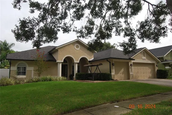a front view of a house with a garden and yard