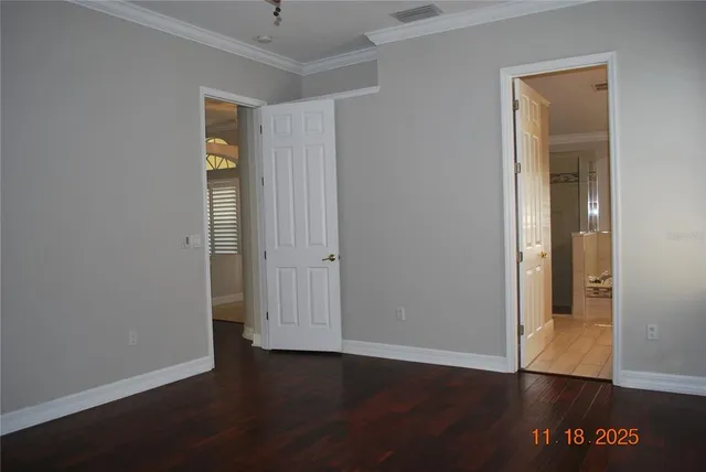 an empty room with wooden floor and closet