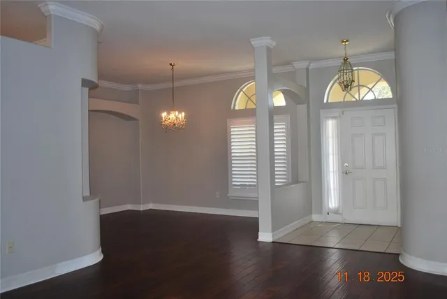 an empty room with wooden floor and window