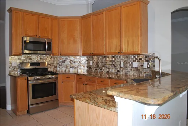 a kitchen with granite countertop a sink stove and microwave