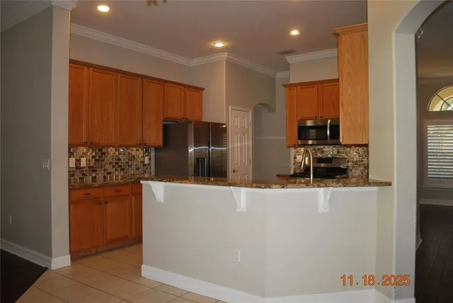a kitchen with stainless steel appliances granite countertop a refrigerator and a stove