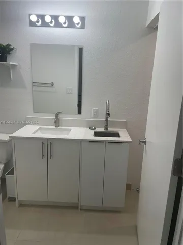 a bathroom with a sink vanity and a mirror