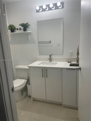 a bathroom with a sink toilet and mirror