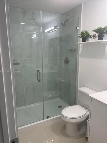 a bathroom with a shower a toilet and a sink
