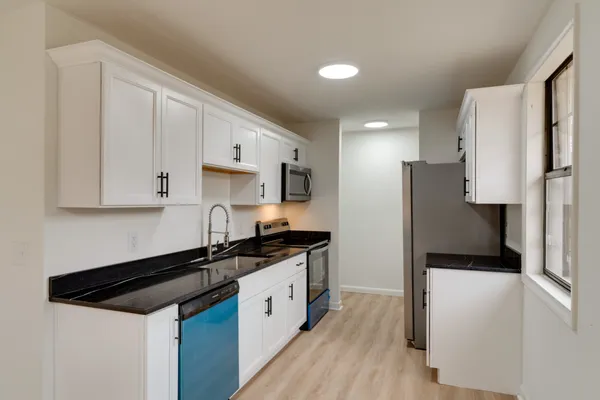 a kitchen with stainless steel appliances a sink stove and refrigerator
