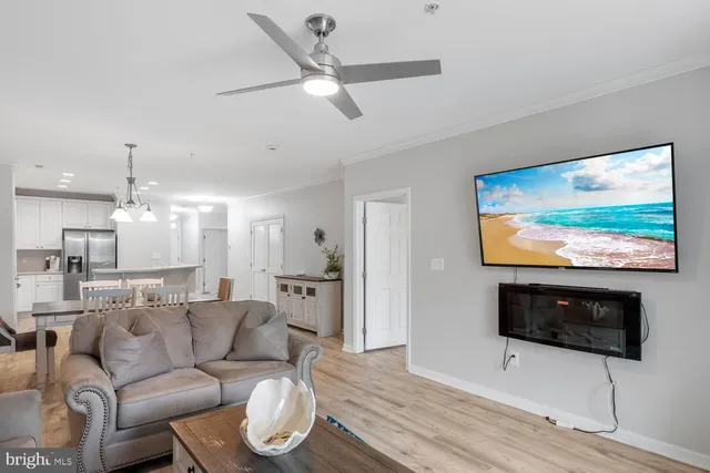 a living room with furniture kitchen view and a chandelier