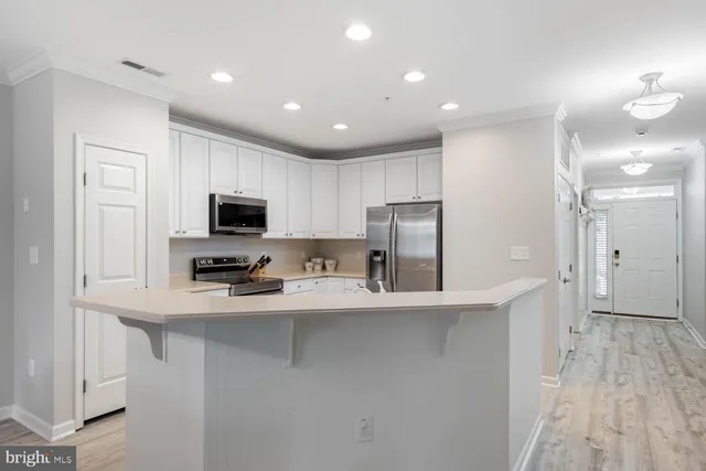 a kitchen with stainless steel appliances a refrigerator sink and microwave
