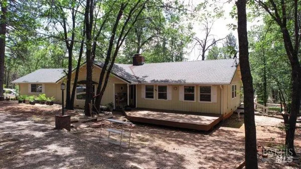 a view of a house with backyard and trees