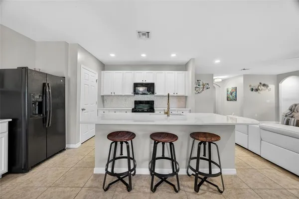 a large kitchen with kitchen island a sink table and chairs