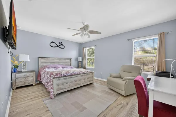 a bedroom with a bed wooden floor and window