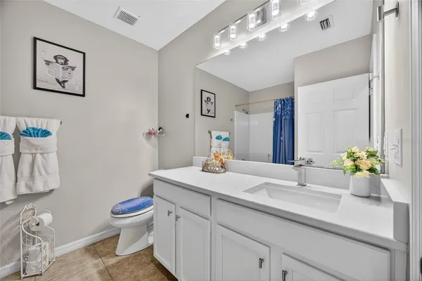 a bathroom with a sink vanity granite and toilet