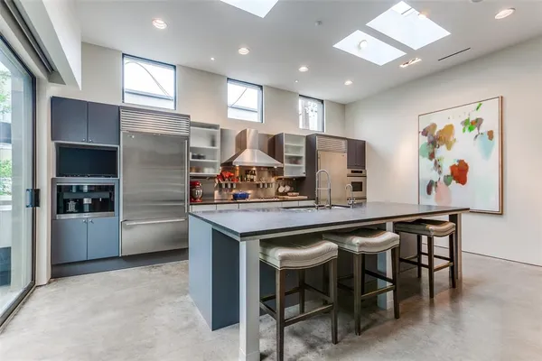 a kitchen with stainless steel appliances granite countertop a sink and a refrigerator