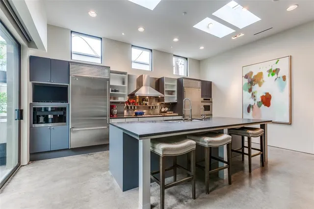 a kitchen with stainless steel appliances granite countertop a sink and a refrigerator