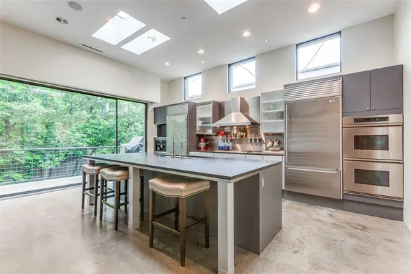 a kitchen with kitchen island granite countertop wooden cabinets and stainless steel appliances