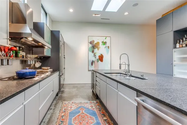 a kitchen with stainless steel appliances granite countertop a sink stove and cabinets