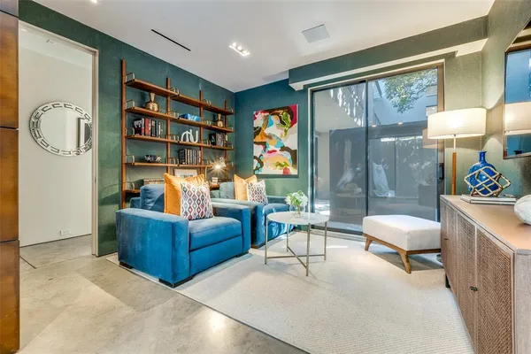 a living room with furniture and a painting on the wall