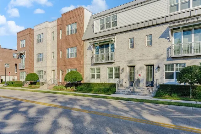 front view of a brick house with a small yard and plants