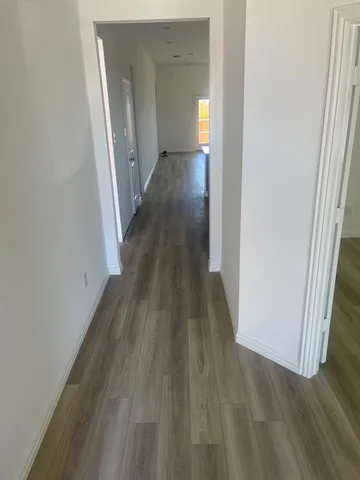 a view of a hallway with wooden floor