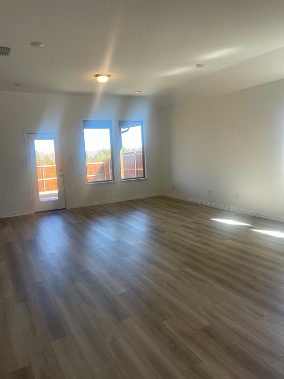 1825 Plymouth Drive Princeton, TX 75407 - Photo 5 of 23 an empty room with wooden floor and windows