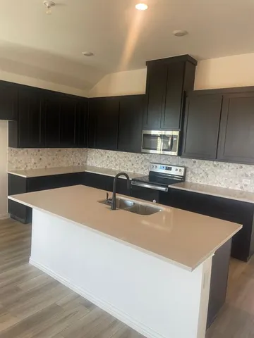 a kitchen with kitchen island a sink and a stove