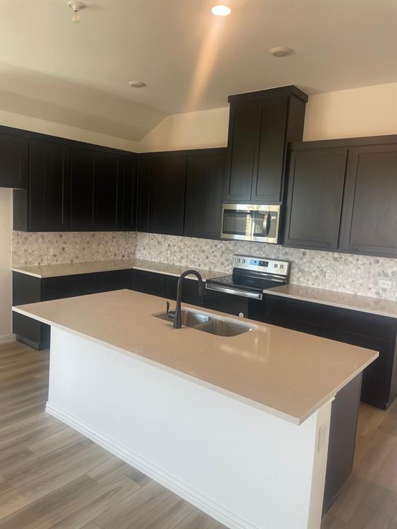1825 Plymouth Drive Princeton, TX 75407 - Photo 8 of 23 a kitchen with kitchen island a sink and a stove