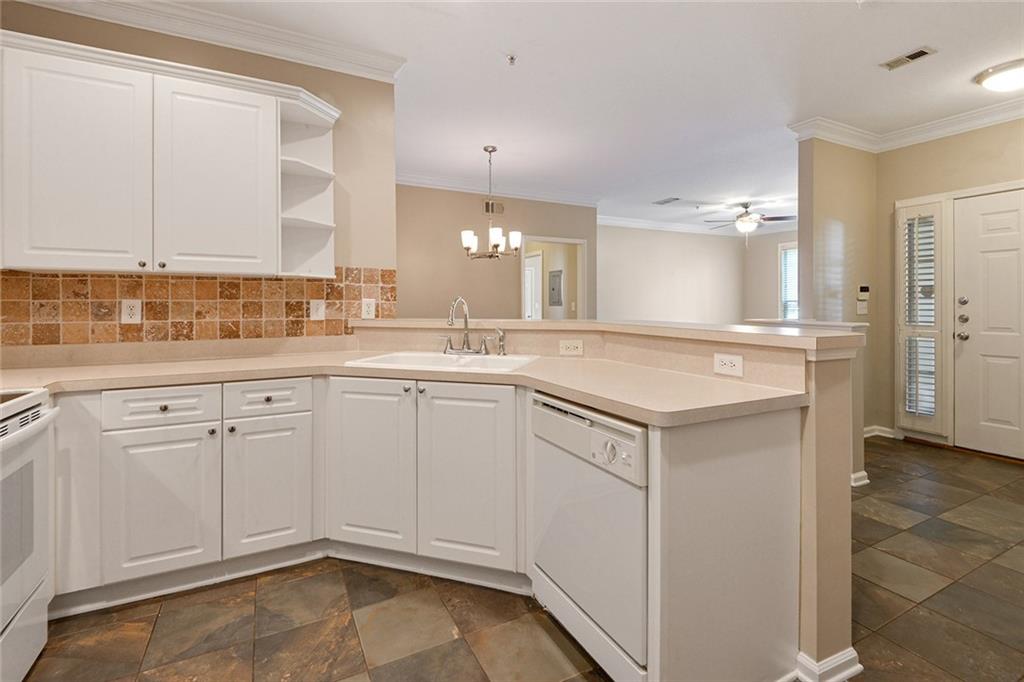 2400 Cumberland Parkway Southeast, Unit 611 Atlanta, GA 30339 - Photo 14 of 26 a white kitchen with a sink and dishwasher with white cabinets