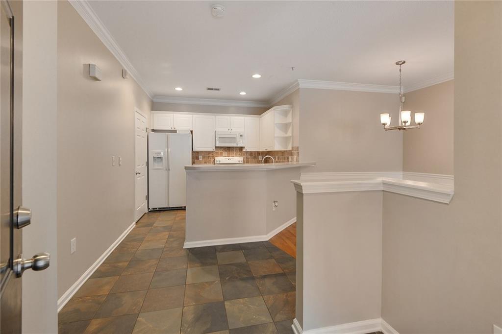 2400 Cumberland Parkway Southeast, Unit 611 Atlanta, GA 30339 - Photo 2 of 26 a kitchen with kitchen island white cabinets and refrigerator
