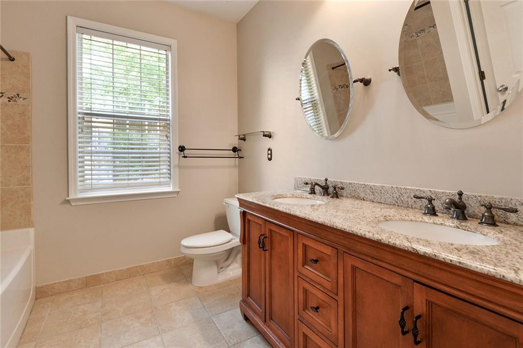 2400 Cumberland Parkway Southeast, Unit 611 Atlanta, GA 30339 - Photo 8 of 26 a bathroom with a granite countertop toilet sink and mirror