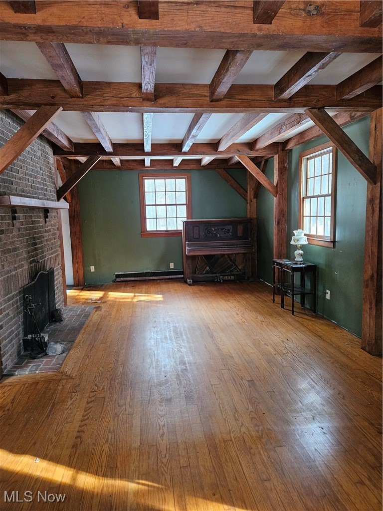 6042 Ford Road Madison, OH 44057 - Photo 9 of 25 Living room with wood-type flooring, a fireplace, beamed ceiling, and baseboard heating