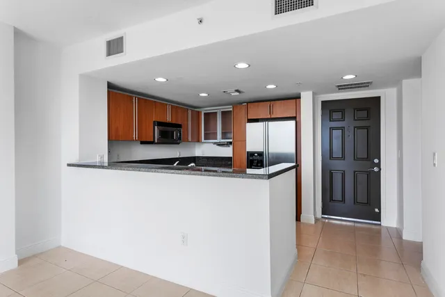 a kitchen with stainless steel appliances granite countertop a refrigerator and a sink
