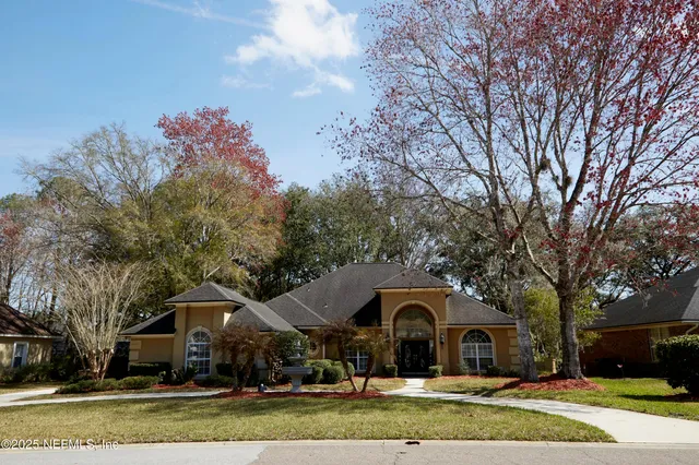 a view of house with garden and tall trees