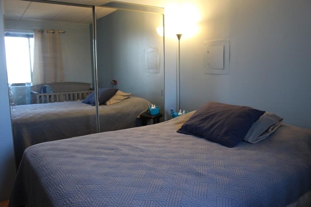 10 Main Street, Unit 507 Framingham, MA 01702 - Photo 11 of 17 a bedroom with a bed and a night stand